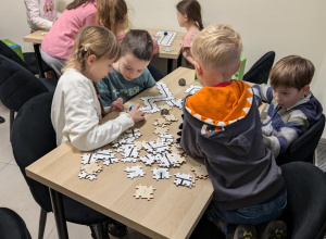 Dzieci siedzą przy stoliku i kodują