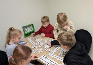 Dzieci siedzą przy stoliku i kodują