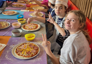 dzieci układają poszczególne produkty na pizze