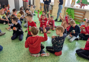 Dzieci siedząc graja na wykonanych instrumentach