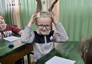 Uczeń prezentuje ośle uszy.