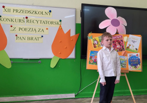 6. Chłopiec na tle okładek recytuje wiersz