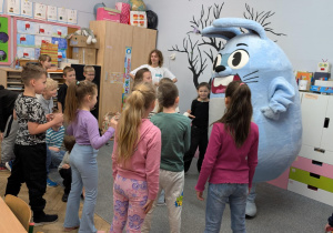 Dzieci tańczą z dużą maskotką królika