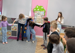 dzieci bawią się stojąc w kole