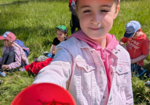 Dziewczynka pokazuje kubeczek z roślinami