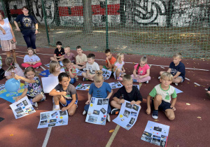 uczniowie prezentują prace na boisku szkolnym