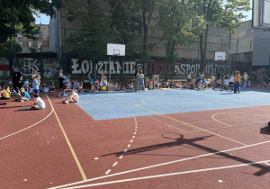 uczniowie prezentują prace na boisku szkolnym