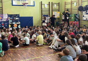 uczniowie siedzący na sali gimnastycznej