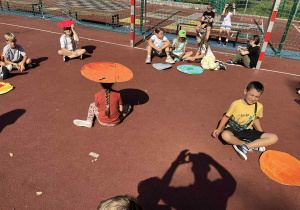 uczniowie prezentują prace na boisku szkolnym