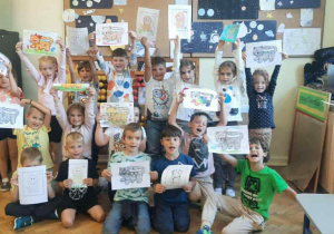 dzieci stoja z kartkami