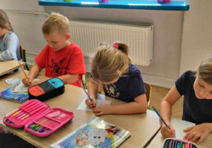 dzieci rysuja na kartkach