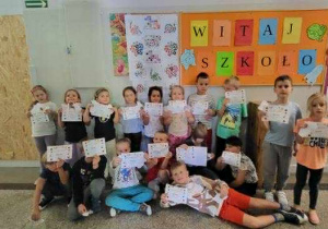 dzieci stoja pod sciana