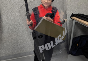 Chłopiec stoi w przebraniu policyjnym