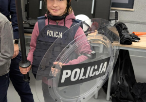 Dziewczynka stoi w przebraniu policyjnym