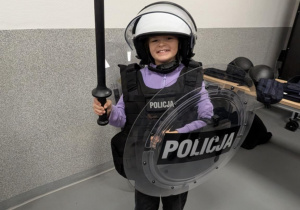 Dziewczynka stoi w przebraniu policyjnym