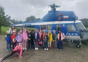 Uczniowie i nauczycielki stoją przed helikopterem