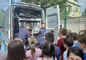 policjanci pokazują wyposażenie radiowozu