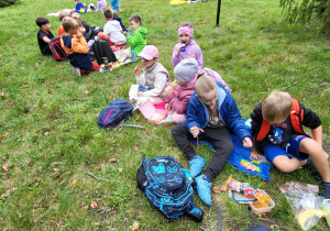 dzieci siedzą na kocach