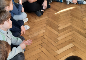 dzieci siedzą na podłodze