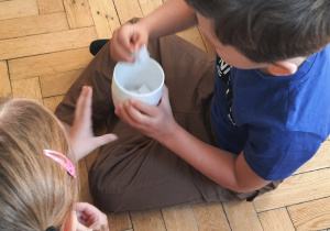 dzieci siedzą na podłodze