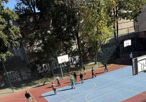 dzieci grają w kosza na boisku