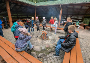 dzieci siedza przy ognisku