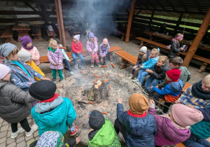 dzieci siedza przy ognisku