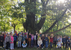 dzieci stoją przy drzewie