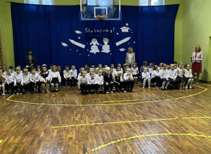 uczniowie siedza na sali gimnastycznej