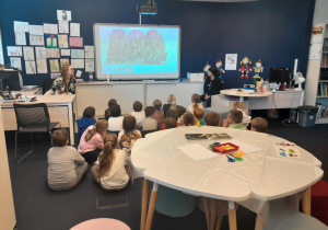 dzieci oglądają prezentacje na podłodze