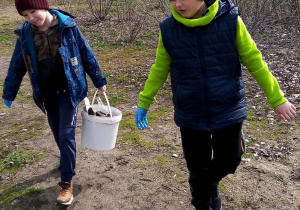 Dwójka uczniów trzymająca worek ze śmieciami