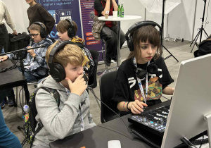 dzieci siedzą przy laptopie