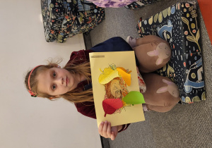 Dziewczynka z jeżem schowanym pod liśćmi