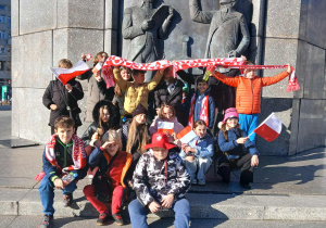 dzieci pozują do zdjęcia pod pomnikiem Tadeusza Kościuszki
