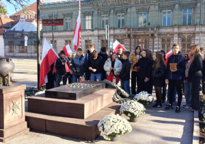 dzieci stoją przy grobie