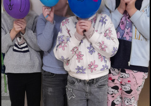 dzieci pozują do zdjęcia z balonami