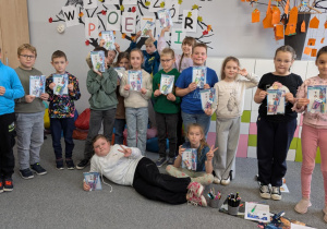 Uczniowie stoją trzymajc pasty i szczoteczki do zębów