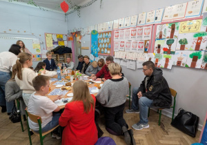 Rodzice z dziećmi siedza przy stołach