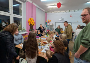 Rodzice z dziećmi siedza przy stołach