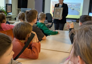 Uczniowie siedzą przy stołach w bibliotece