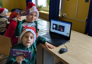 dzieci siedzą przy komputerze