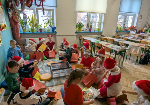 dzieci siedzą w klasie na podłodze