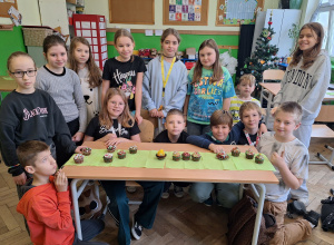 uczniowie stoją przy stole