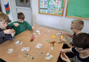 Dzieci trenują szycie igłą