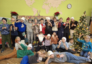 Uczniowie prezentuja wykonane ozdoby i czapki