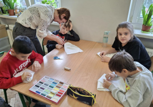 Uczniowie uczą się szyć czapki