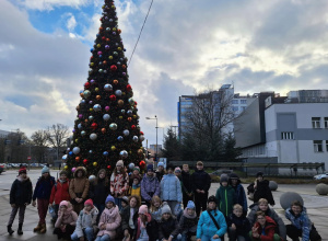 dzieci stoją przed choinką