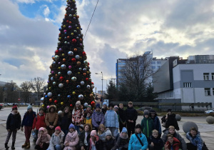 dzieci stoją przed choinką