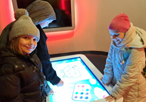 uczniowie stoją przy tablecie