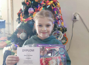 uczennica z dyplomem i nagrodą z konkursu